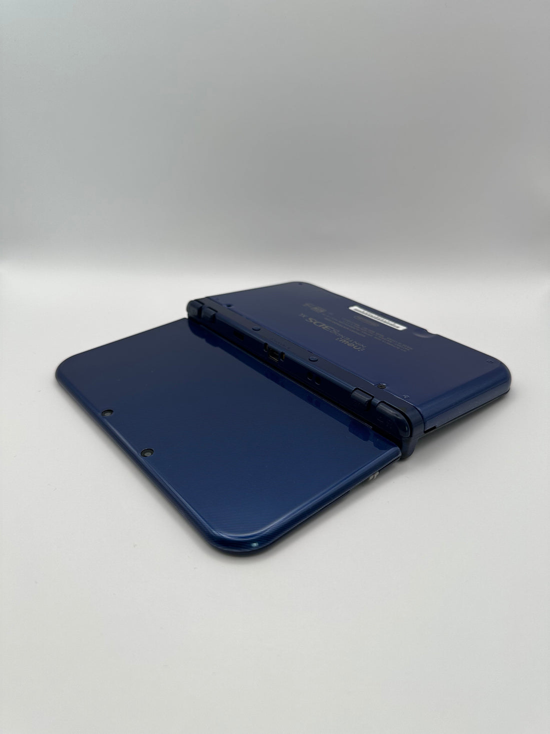 ReCollected New Nintendo 3DS XL in Blau, aufgeklappt von der Rückseite gezeigt, in sehr gutem Zustand.
