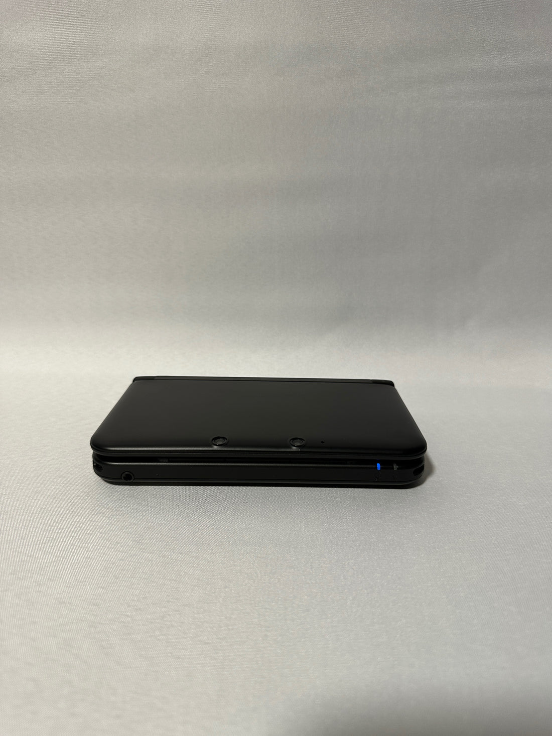 ReCollected New Nintendo 3DS XL Konsole in Schwarz, zusammengeklappt mit leuchtender blauer Status-LED